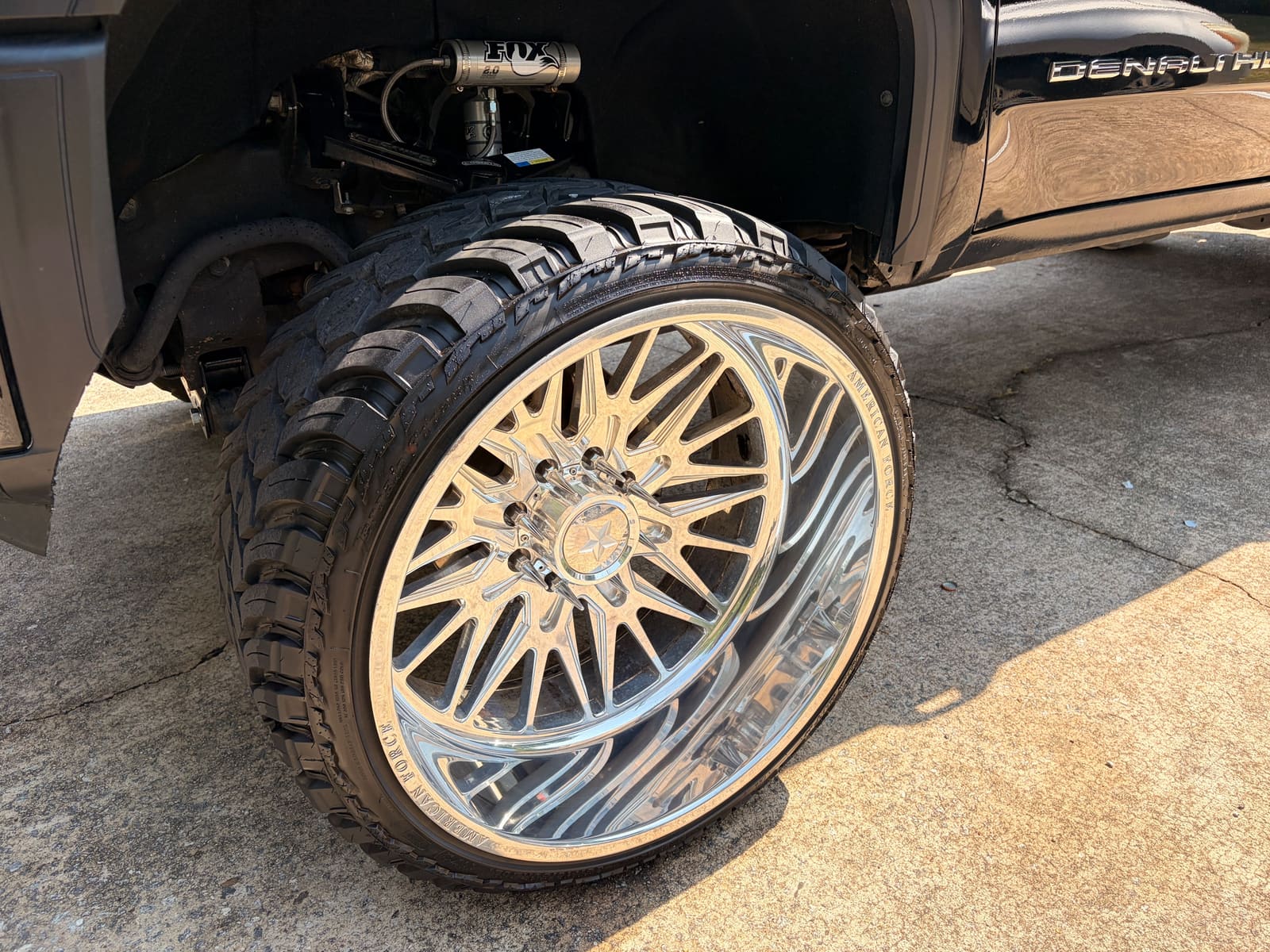 Polished chrome wheel on a lifted truck after a wheel and tyre clean