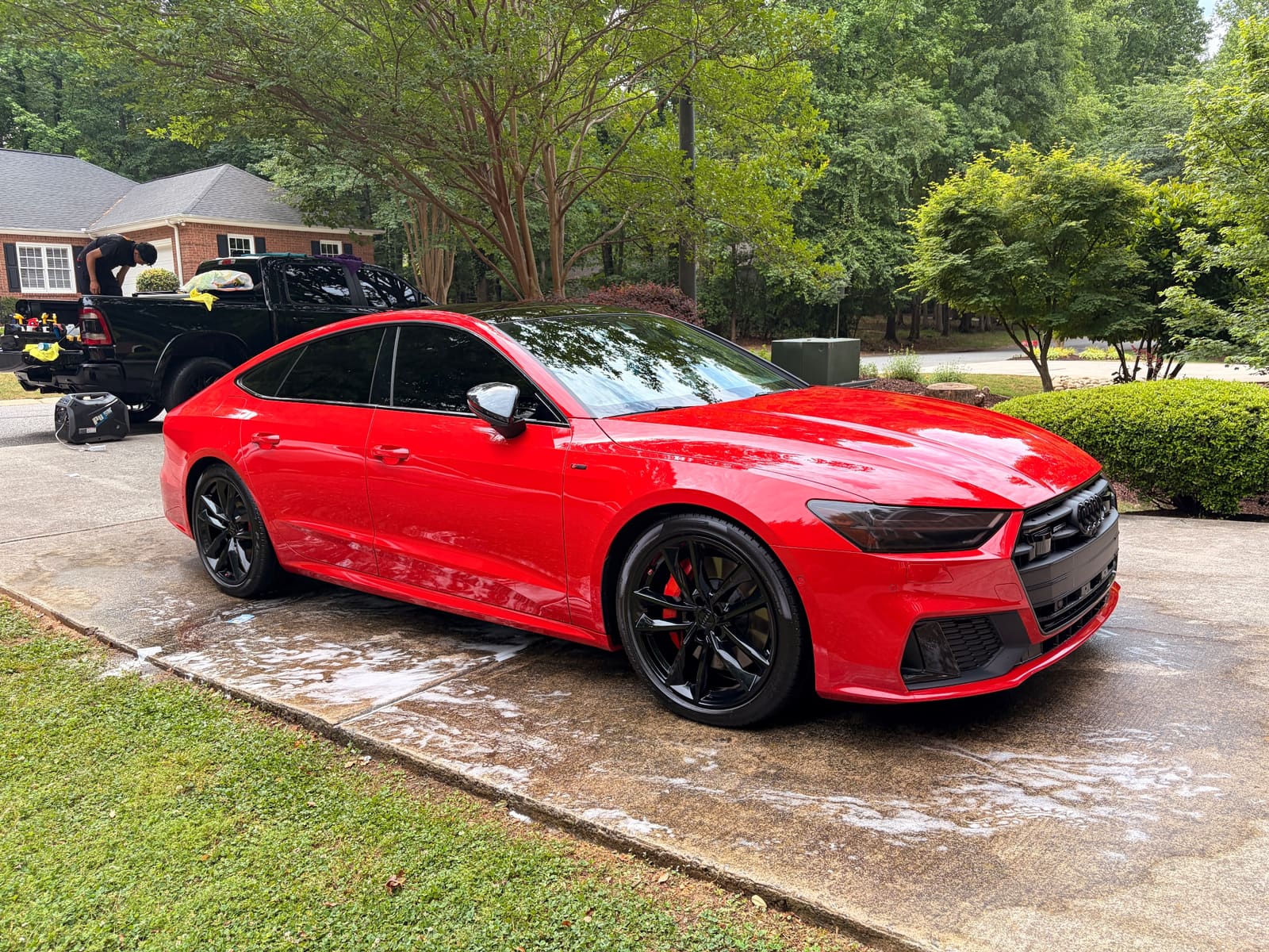 Red Audi RS 7 being hand washed on a driveway