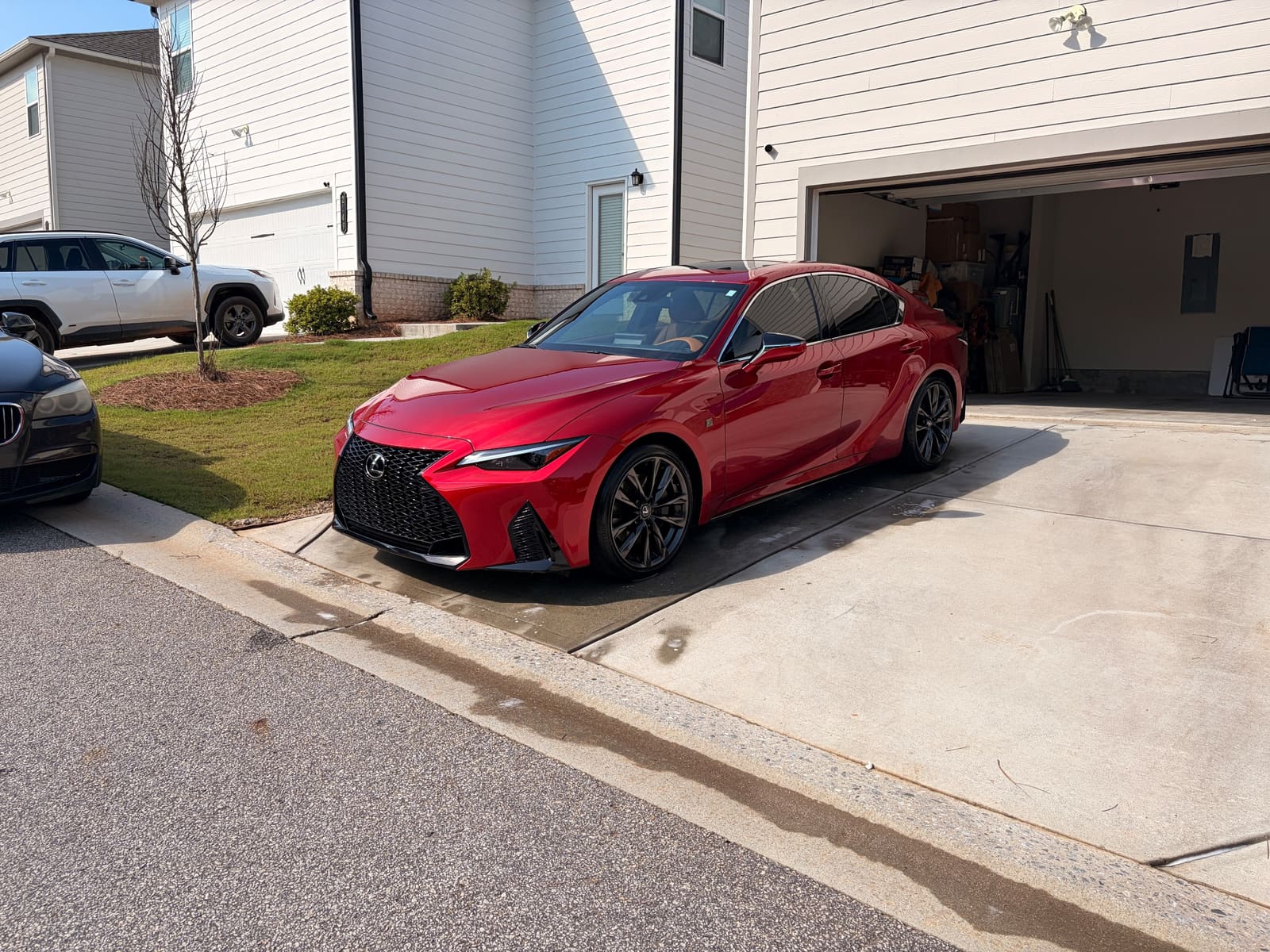 Red Lexus IS parked on a driveway after a full detail
